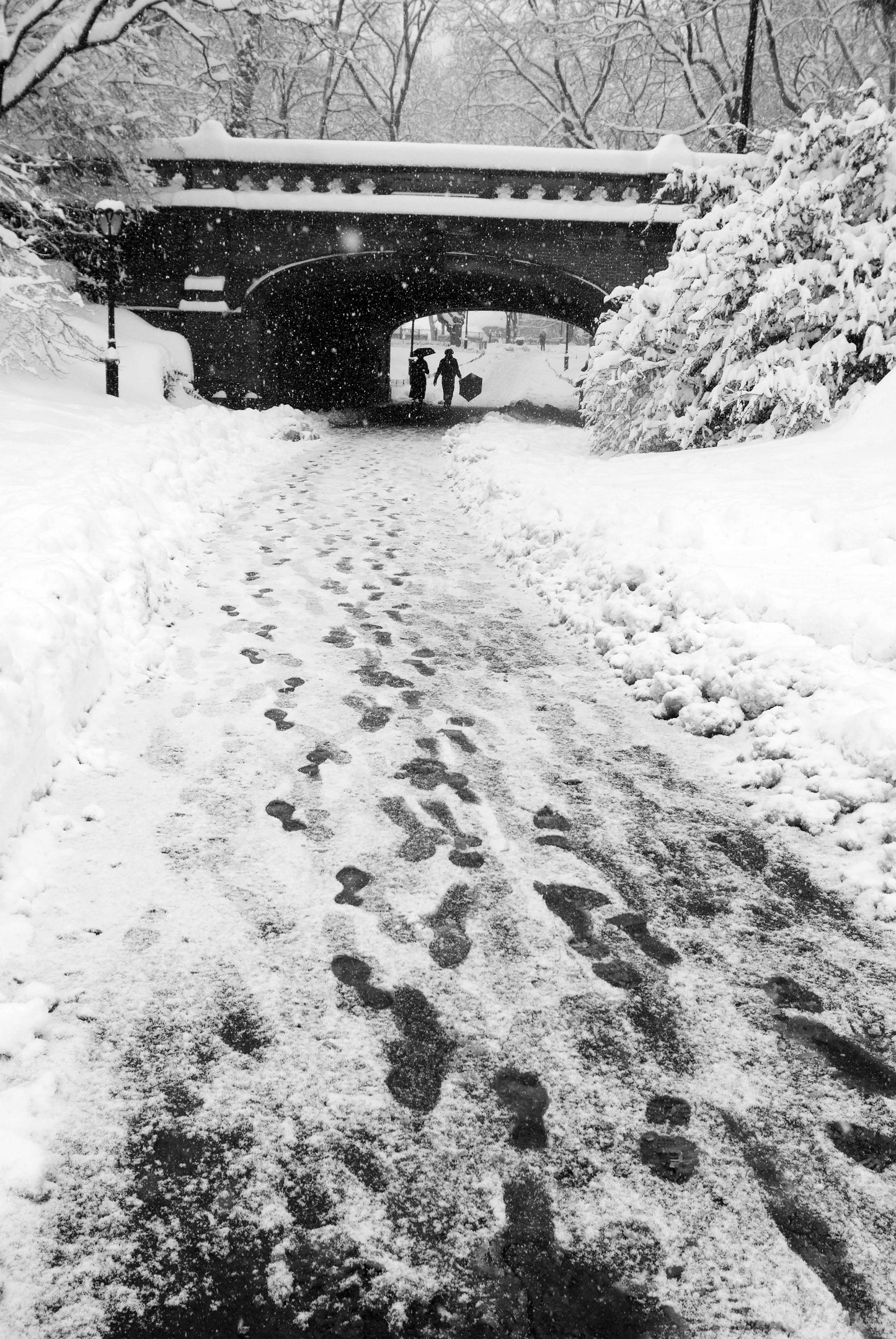 Alessandra Mattanza | FOOT PRINTS UNDER A BRIDGE, Central Park, New York. The snowy impression of people passing under the Driprock Arch in Central Park. Available as a photographic print on acrylic glass.